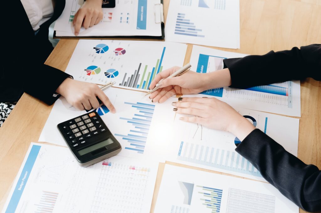 Business People Meeting using calculator,stock market chart paper for analysis Plans to improve